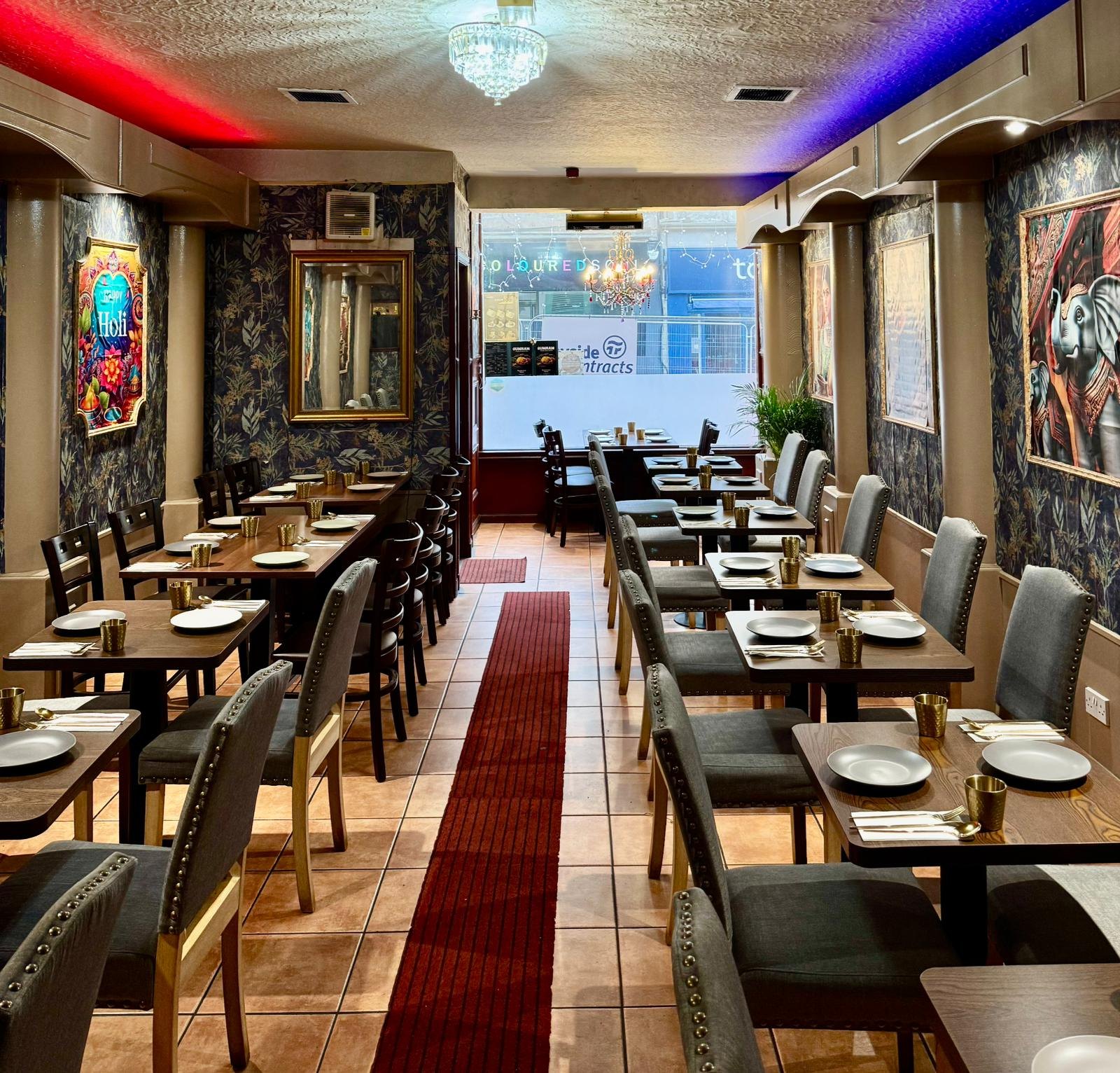 The full dining room looking towards the Union Street window, tables set either side of a red runner