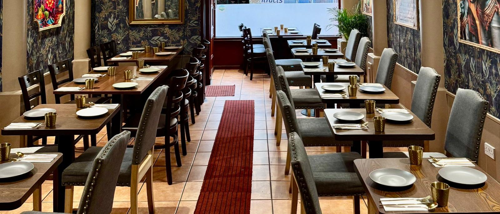 The full dining room looking towards the Union Street window, tables set either side of a red runner